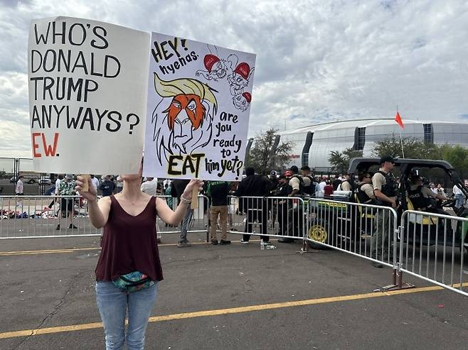 트럼프 대통령에 반대하는 시위자 (글렌데일[미 애리조나주]=연합뉴스) 임미나 특파원 = 21일(현지시간) 오전 찰리 커크 추모식이 열린 미국 애리조나주 피닉스 외곽 글렌데일의 스테이트팜 스타디움 밖에서 트럼프 대통령에 반대하는 미셸 리처드 씨가 피켓을 들고 있다. mina@yna.co.kr