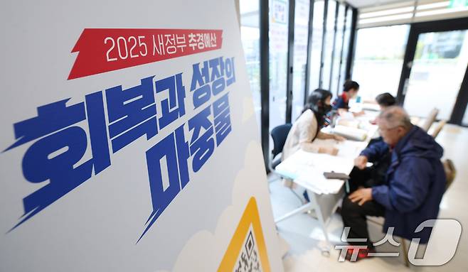 전 국민의 90%에게 10만원씩 지급하는 '민생회복 소비쿠폰'의 2차 신청 첫날인 22일 경기 수원시 팔달구 고등동행정복지센터에서 시민들이 소비쿠폰 신청을 하고 있다. 2025.9.22/뉴스1 ⓒ News1 김영운 기자