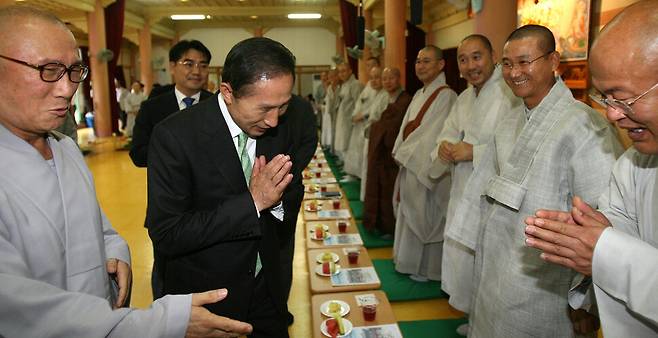 이명박 전 대통령이 2007년 7월16일 조계종 본말사 주지회의가 열리는 경기 화성시 용주사를 방문, 스님들과 합장 인사를 나누고 있다. 연합뉴스
