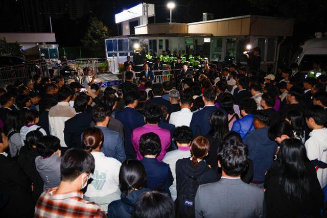 윤석열 전 대통령 부부에게 통일교 현안을 청탁했다는 의혹을 받는 한학자 통일교 총재가 구속된 23일 새벽 경기 의왕시 서울구치소 앞에서 한 총재를 기다리던 신도들이 통일교측 관련 입장을 듣고 있다. 뉴스1