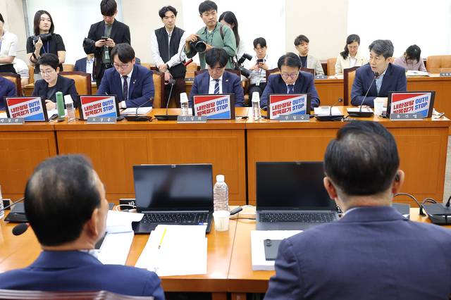 22일 서울 여의도 국회에서 정부조직법 개정안 의결을 앞두고 열린 행정안전위원회 전체회의에서 민주당 의원들이 자리에 국민의힘 규탄 팻말을 놓은 채 회의에 참석하고 있다. 2연합뉴스