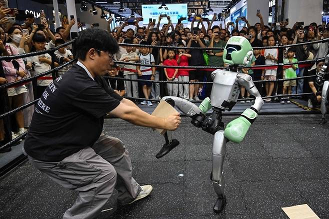 중국 상해에서 열린 세계 인공지능 컨퍼런스 도중 로봇이 송판을 깨고 있다. [AFP]