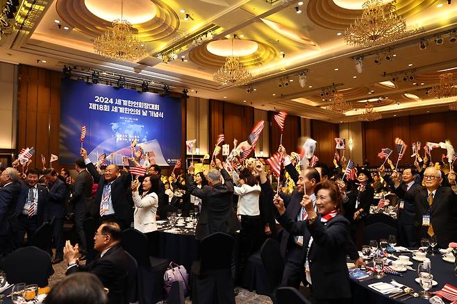 '2024 세계한인회장대회' 개막식 (서울=연합뉴스) 서울 잠실 롯데호텔 월드에서 열린 '2024 세계한인회장대회' 개막식에 참석한 한인회장들이 태극기를 흔들고 있다. [재외동포청 제공]