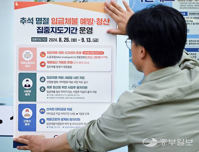 수원시 장안구 고용노동부 경기지청에서 관계자가 '추석 명절 임금체불 예방·청산 집중지도기간' 관련 포스터를 게시하고 있다.&nbsp; 사진=중부일보DB