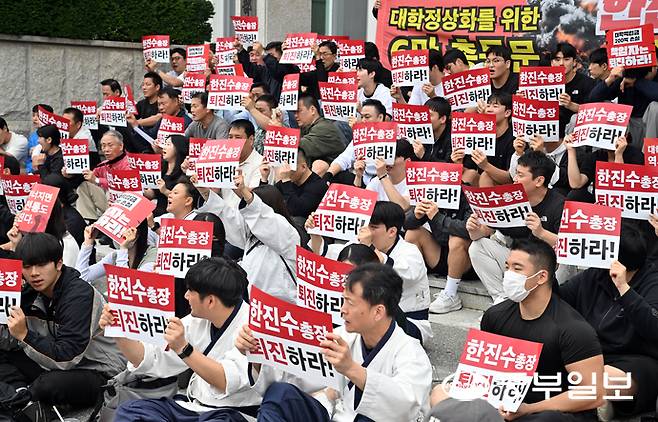 24일 오전 용인시 용인대학교 본관 앞에서 용인대 총동문회와 학생들이 학교 정상화를 촉구하며 손피켓을 들고 구호를 외치고 있다. 김경민기자