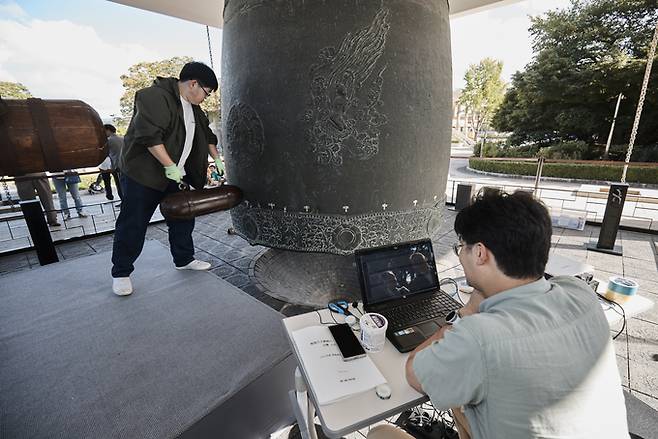 ▲ 국립경주박무관이 24일 열린 성덕대왕신종 타음조사 공개회를 앞두고 지난 23일 작은 타봉을 이용해 종의 맥놀이 현상과 고유 진동 주파수를 측정하고 있다. 국립경주박물관