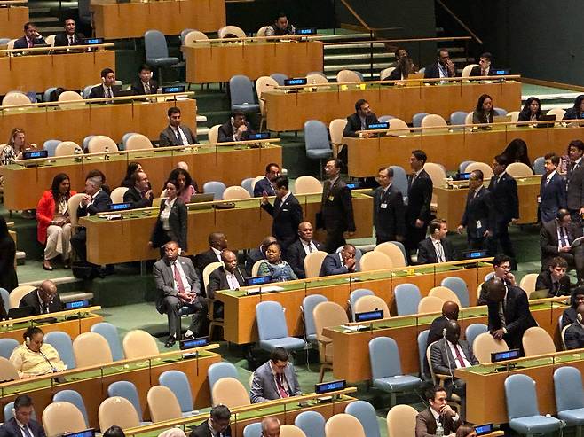 23일 미국 뉴욕 유엔본부에서 열린 총회에 이재명 대통령이 입장하고 있다. 이 대통령은 과테말라 대표부 자리에 웃으며 손을 흔들었고, 과테말라 측 인사(왼쪽 가운데)도 앉은 채 웃으며 손을 들었다./윤주헌 특파원