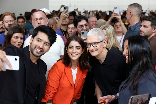 지난 9일(현지 시각) 미국 캘리포니아 애플 파크에서 열린 신제품 발표 행사 직후, 팀 쿡 애플 최고경영자(CEO)가 인도 유명 가수, 기업인과 기념사진을 찍고 있다. 실리콘밸리 기업들은 공개 행사에 유명 아티스트나 크리에이터들을 불러 파티 같은 분위기를 연출하는데, 자유와 창의성을 중시하는 기업 문화를 보여준다는 분석이 나온다./AP 연합뉴스