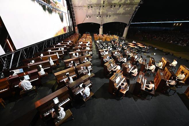 지난해 9월 대구 달성군 사문진 상설 야외공연장에서 열린 ‘달성 100대 피아노 공연’. 100명의 피아니스트가 100대의 피아노로 합주하는 장면이 장관을 이뤘다. 대구 달성군 제공