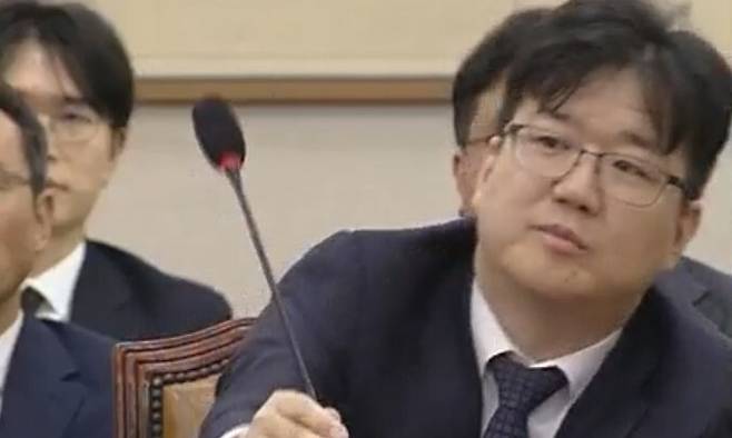 ‘관봉권 띠지 분실’ 당시 서울남부지검 수사팀장이었던 최재현 검사가 국회 청문회 질의 과정에서 마이크를 윗쪽으로 세우는 모습. 국회의사중계시스 갈무리
