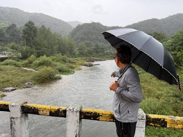 ▲ 양구군 방산면 두타연 인근 하천에서 한 마을 주민이 수질오염 의심 지점을 가리키고 있다.  박재혁 기자