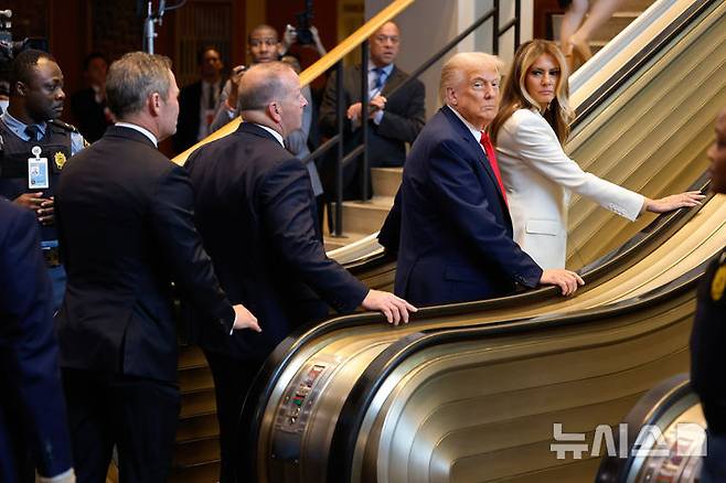 [뉴욕=AP/뉴시스] 도널드 트럼프 미국 대통령과 멜라니아 트럼프 여사가 23일(현지 시간) 미국 뉴욕의 유엔 본부에서 열린 제80차 고위급 회기 일반토의 참석을 위해 에스컬레이터를 이용하고 있다. 트럼프 대통령의 유엔 총회 연설은 5년만이며, 직접 총회장에서 연설하는 것은 2019년 이후 처음이다. 2025.09.24.