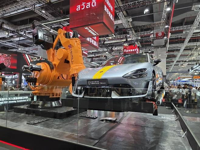 24일 중국 상하이 국제컨벤션센터에서 열린 세계 최대 규모의 산업 로봇 전시회인 ‘2025 로봇박람회’에 5t까지 버틸 수 있는 중국 기업 ‘차이푸’의 초대형 로봇팔 ‘알프틱 5000KG’가 샤오미 자동차를 들어올리고 있다. 상하이 곽소영 기자