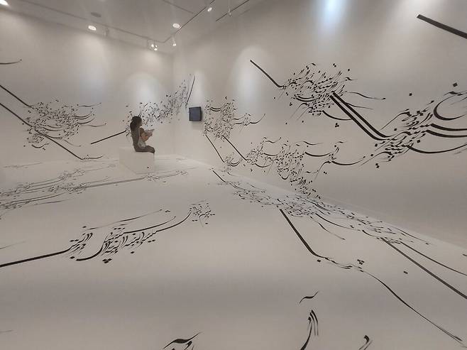 아랍 문자를 힘차게 물결치는 듯한 이미지로 표현하며 전시장 벽과 바닥을 덮은 이란 작가 파라스투 포로우하르의 설치 작품 ‘쓰여진 방’(Written Room). 전남수묵비엔날레 본전시장 격인 목포문화예술회관 4전시실에서 볼 수 있다. 노형석 기자