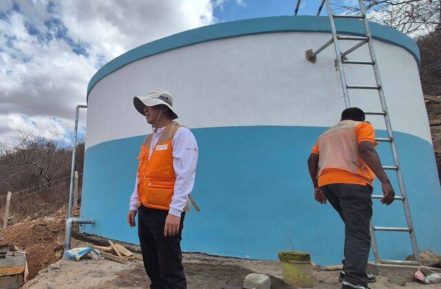 정대령(왼쪽) 홍제감리교회 목사가 멤베 마을에 설치된 물탱크 앞에 서 있는 모습.