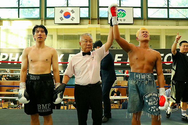 이태동이 2025년 9월 서울특별시 관악구민종합체육센터 사단법인 한국복싱커미션 라이트헤비급 챔피언결정전 승리 선언을 들으며 감격하고 있다. 왼쪽은 슈퍼미들급 타이틀 도전자 출신 김동우. 사진=KBM