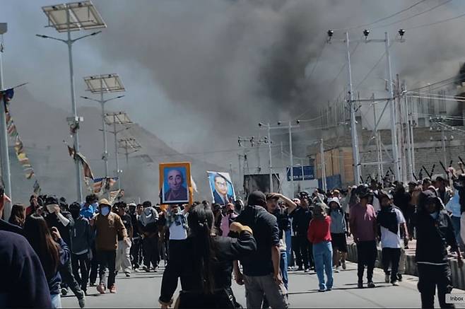 [레(인도 라다크주)=AP/뉴시스]인도 라다크주 주도 레에서 24일 더 큰 자치권을 요구하는 시위가 폭력 사태로 번지면서 집권 인도인민당(BJP) 사무실에 불이 붙어 검은 연기가 치솟고 있다. 인도 당국은 하루 만인 25일 레와 카르길 두 곳에 통금령을 선포하고 5명 이상의 집회를 금지시켰다. 2025.09.25.