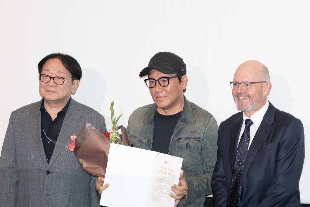 25일 오후 부산 해운대구 영화의전당 소극장에서 열린 'CHANEL X BIFF 아시아영화아카데미' 수료식에서 교장 김지운(가운데) 감독이 감사장을 받고 있다. 왼쪽은 박광수 부산국제영화제(BIFF) 이사장, 오른쪽은 클라우스 올데거 샤넬코리아 대표. 정성운 인턴기자