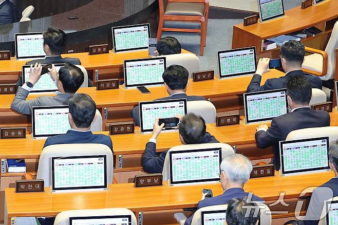 26일 서울 여의도 국회에서 열린 제429회국회(정기회) 9차 본회의에서 검찰청 폐지를 골자로 한 정부조직법 개정안이 통과되자 의원들이 스마트폰으로 사진을 남기고 있다. 2025.9.26/뉴스1 ⓒ News1 신웅수 기자