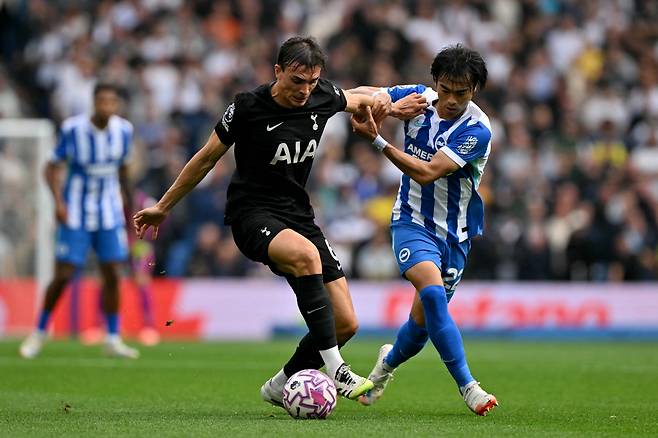Tottenham Hotspur's Portugese midfielder #06 Joao Palhinha battles for the ball with Brighton's Japanese midfielder #22 Kaoru Mitoma during the English Premier League football match between Brighton and Hove Albion and Tottenham Hotspur at the American Express Community Stadium in Brighton, southern England on September 20, 2025. (Photo by Glyn KIRK / AFP) / RESTRICTED TO EDITORIAL USE. No use with unauthorized audio, video, data, fixture lists, club/league logos or 'live' services. Online in-match use limited to 120 images. An additional 40 images may be used in extra time. No video emulation. Social media in-match use limited to 120 images. An additional 40 images may be used in extra time. No use in betting publications, games or single club/league/player publications. / <저작권자(c) 연합뉴스, 무단 전재-재배포, AI 학습 및 활용 금지>