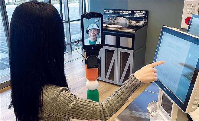 일본 대표 편의점 체인 세븐일레븐이 인력난에 대응하기 위해 오사카의 한 매장에서 원격 서비스로 손님에게 계산을 안내하는 모습.  /일본 세븐일레븐 제공