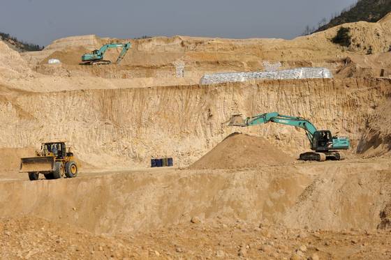 Workers use machinery to dig at a rare earth mine in Ganxian county in central China's Jiangxi province on Dec. 30, 2010. [AP/YONHAP]