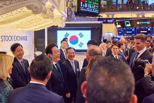 이재명 대통령이 25일(현지시간) 미국 뉴욕증권거래소에서 관계자들과 웃으며 이야기를 나누고 있다.[ 연합]