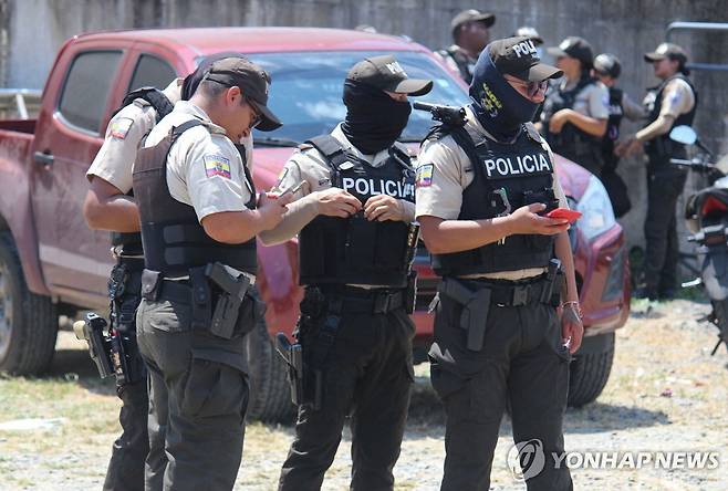 25일(현지시간) 수감자 폭동이 발생한 교도소 인근에서 대화 중인 경찰 [에스메랄다스 AFP=연합뉴스. 재판매 및 DB 금지]
