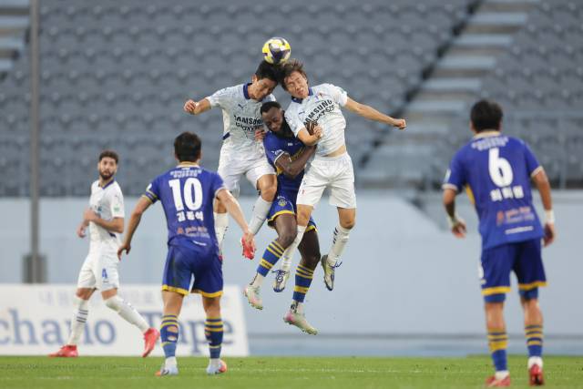 27일 오후 이순신종합운동장에서 치러진 '하나은행 K리그2 2025' 31라운드 아산과 수원삼성블루윙즈의 경기는 원정팀 수원의 3대 1 승리로 마무리됐다. 아산 은고이(가운데)가 수원 선수들과 공중볼 경합을 하고 있다. 한국프로축구연맹 제공.