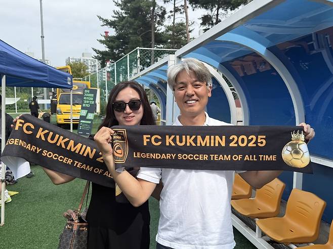 이성규 국민일보 사회부장과 아내가 응원 수건을 들고 미소를 짓고 있다. /한국기자협회