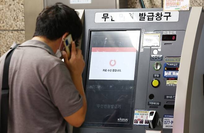 ▲ 27일 서울 시내 한 지하철역에 설치된 무인민원발급기에서 한 시민이 서류가 발급되지 않자 통화를 하고 있다 [연합뉴스]