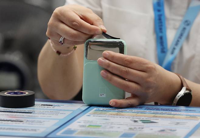 항공사 직원이 승객의 보조배터리 충전 연결부분에 절연 테이프를 부착하고 있다./사진=연합뉴스