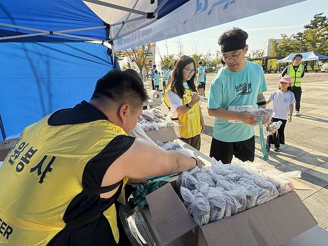[인천=뉴시스] 신유림 기자=국내 최대 민영 뉴스통신사 뉴시스가 주최하고, 로드 스포츠가 주관하며, 인천광역시 중구청과 대한체육회가 후원하는 '제 1회 뉴시스 바다 마라톤'의 '자원봉사자 한영석 씨가 27일  인천광역시 영종도 하늘구름광장에서 펼쳐진 대회에 참석해 참가들에게 메달과 간식을 나눠주고 있다. 2025.09.27. spicy@newsis.com  *재판매 및 DB 금지