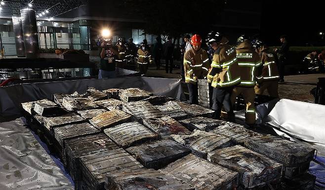 27일 밤 대전 유성구 국가정보자원관리원 화재 현장에서 소방대원이 소화수조에 불에 탄 리튬이온 배터리를 넣고 있다. 연합뉴스