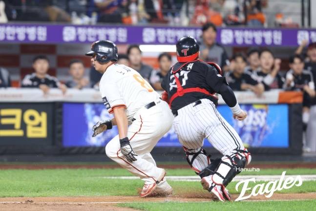 한화 노시환(왼쪽)이 26일 대전 LG전 7회말 1사 2, 3루에서 박동원의 태그를 피해 홈을 밟고 있다. /사진=한화 이글스 제공