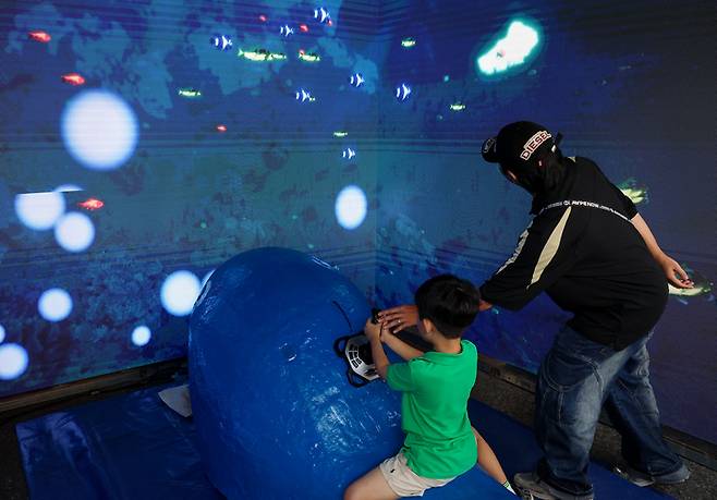 2025 울산고래축제가 열리고 있는 지난 27일 과학체험존 부스를 찾은 관람객이 고래를 타고 떠나는 바다 여행 체험을 하고 있다. 이수화 기자