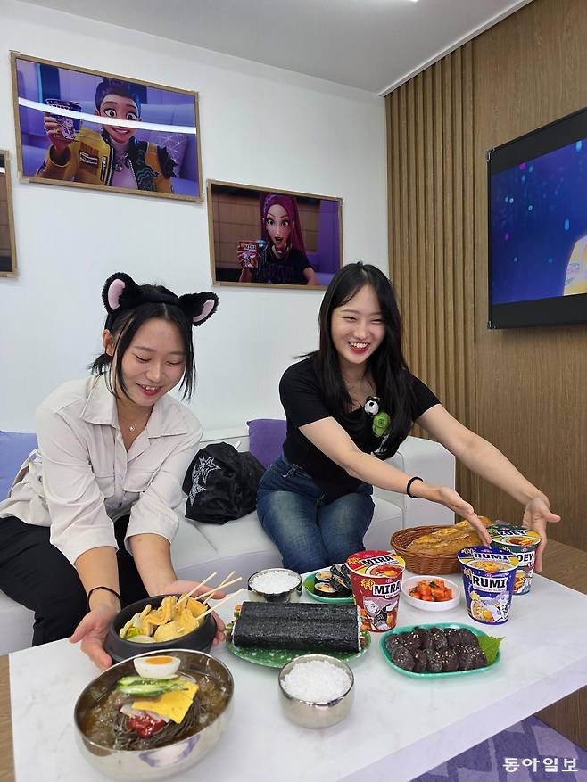 용인 에버랜드에 지난 26일 개장한 케이팝데몬헌터스 테마존. 헌트릭스 멘버들이 비행기에서 먹던 김밥, 떡볶기, 라면 앞에서 기념사진 촬영을 하고 있다 . 전승훈 기자 raphy@donga.com