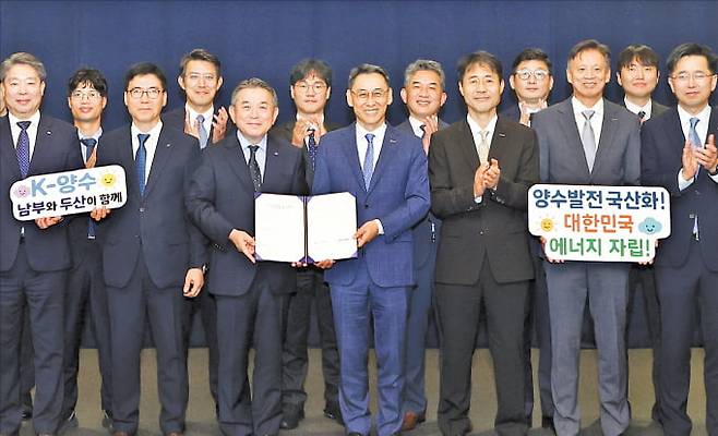 지난 16일 경기도 성남시 분당두산타워에서 열린 양수발전 기자재 국산화 MOU 체결식에서 참석자들이 기념촬영을 하고 있다. 두산에너빌리티 제공
