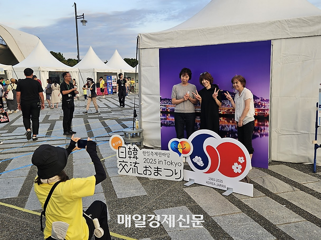 남산타워를 중심으로 한 야경 입간판을 배경으로 사진을 찍는 사람들. [도쿄 이승훈 특파원]