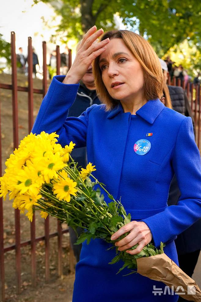 [AP/뉴시스] 몰도바의 친서방 마이아 산두 대통령이 28일 총선 투표를 마치고 부케을 들고 투표소를 나서고 있다