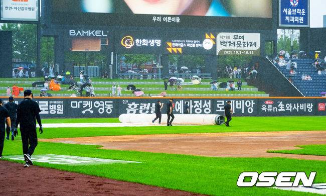 [OSEN=대전, 민경훈 기자] 28일 오후 대전 한화생명볼파크에서 2025 신한 SOL Bank KBO리그 한화 이글스와 LG 트윈스의 경기가 열릴 예정이지만 그라운드에 비가 내리고 있다.프로야구 LG 트윈스의 정규리그 우승 확정이 걸린 대전 경기가 폭우 속에서도 개최 준비를 한다. 경기 개시 시간을 1시간 늦춰 들어갈 예정이다. 빗줄기가 다시 굵어지자 치워졌던 대형 방수포가 다시 깔리고 있다. 2025.09.28 / rumi@osen.co.kr