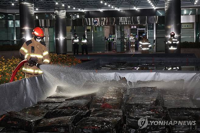 국정자원 화재 현장, 소화수조에 담긴 리튬이온 배터리 (대전=연합뉴스) 배재만 기자 = 27일 밤 대전 유성구 국가정보자원관리원 화재 현장에서 소화수조에 담긴 불에 탄 리튬이온 배터리에 소방대원이 물을 뿌리고 있다. 2025.9.27 scoop@yna.co.kr
