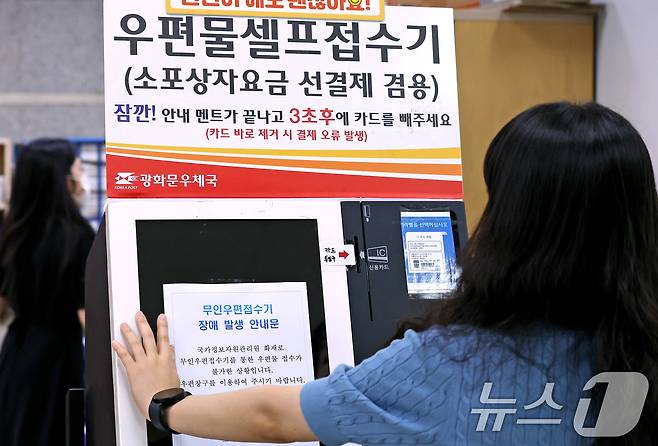 29일 서울 종로구 광화문우체국 내 무인우편접수기에 직원이 국가정보자원관리원 화재로 인한 장애 안내 발생 안내문을 붙이고 있다. 우정사업본부는 이날 9시부터 우편 서비스 일부 업무를 창구 업무를 통해 재개한다고 밝혔다. 2025.9.29/뉴스1 ⓒ News1 장수영 기자