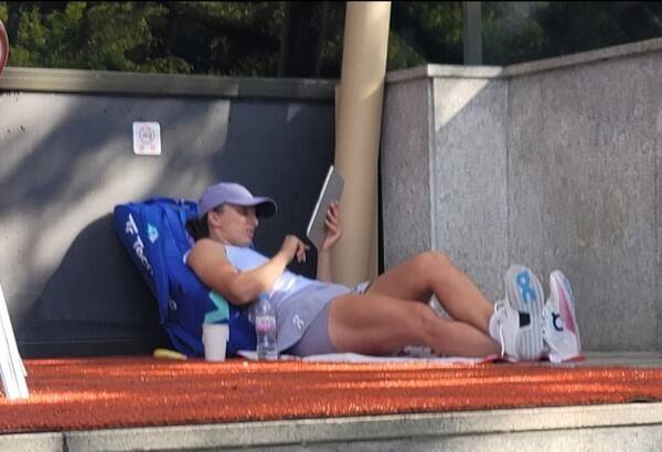2025 코리아오픈 테니스대회에서 출전한 올 윔블던 우승자 이가 시비옹테크(폴란드)가 코트 밖 땅바닥에 수건을 깔고 누워 동영상을 보고 있다. 독자 제공