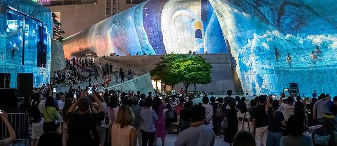 지난달 28일 서울 중구 동대문디자인플라자(DDP)에서 열린 ‘서울라이트 DDP 2025 가을’을 찾은 시민들과 외국인 관광객들이 미디어파사드 작품을 관람하고 있다. 서울디자인재단 제공