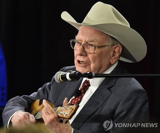 한 자선행사에 참석한 '투자의 귀재' 워런 버핏이 카우보이 모자를 쓰고 우쿨렐레를 연주하고 있다. 연합뉴스
