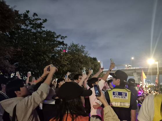 지난 27일 서울 여의도 한강공원에서 '2025 서울세계불꽃축제'가 열리고 있는 가운데, 경찰이 하늘을 등지고 시민들을 지켜보고 있다. 전율 기자