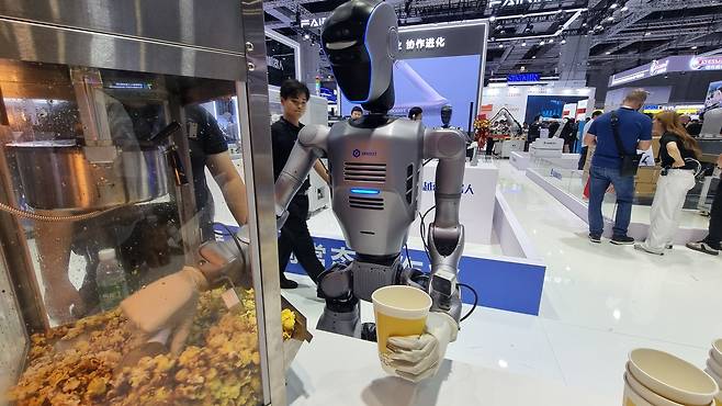 중국 선전에 위치한 산업용 협동로봇 제조기업 ‘두봇(Dobot)’의 휴머노이드 로봇 ‘ATOM’이 지난 23일(현지시간) 중국 상하이 국가컨벤션센터(NECC)에서 열린 ‘중국국제산업박람회(CIIF·Chinese International Industry Fair)’ 전시장에서 팝콘을 컵에 담고 있다. [김영철 기자]