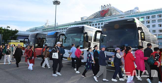 [인천=뉴시스] 전진환 기자 = 중국인 단체관광객에 대한 무비자 입국 시행 첫날인 29일 오전 인천 연수구 인천항 크루즈터미널에서 중국인 단체 크루즈 관광객이 입국해 버스로 향하고 있다.  2025.09.29. amin2@newsis.com
