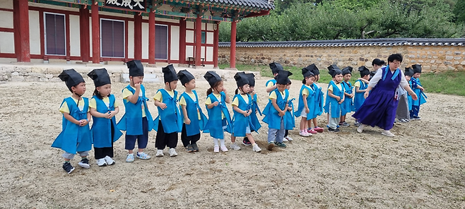 ▲ 29일 경북 의성향교 대성전 앞마당에서 에덴유치원 원생들이 전통 유복을 입고 예절 체험 수업에 참여하며 지도 교사의 안내를 받고 있다. 의성향교